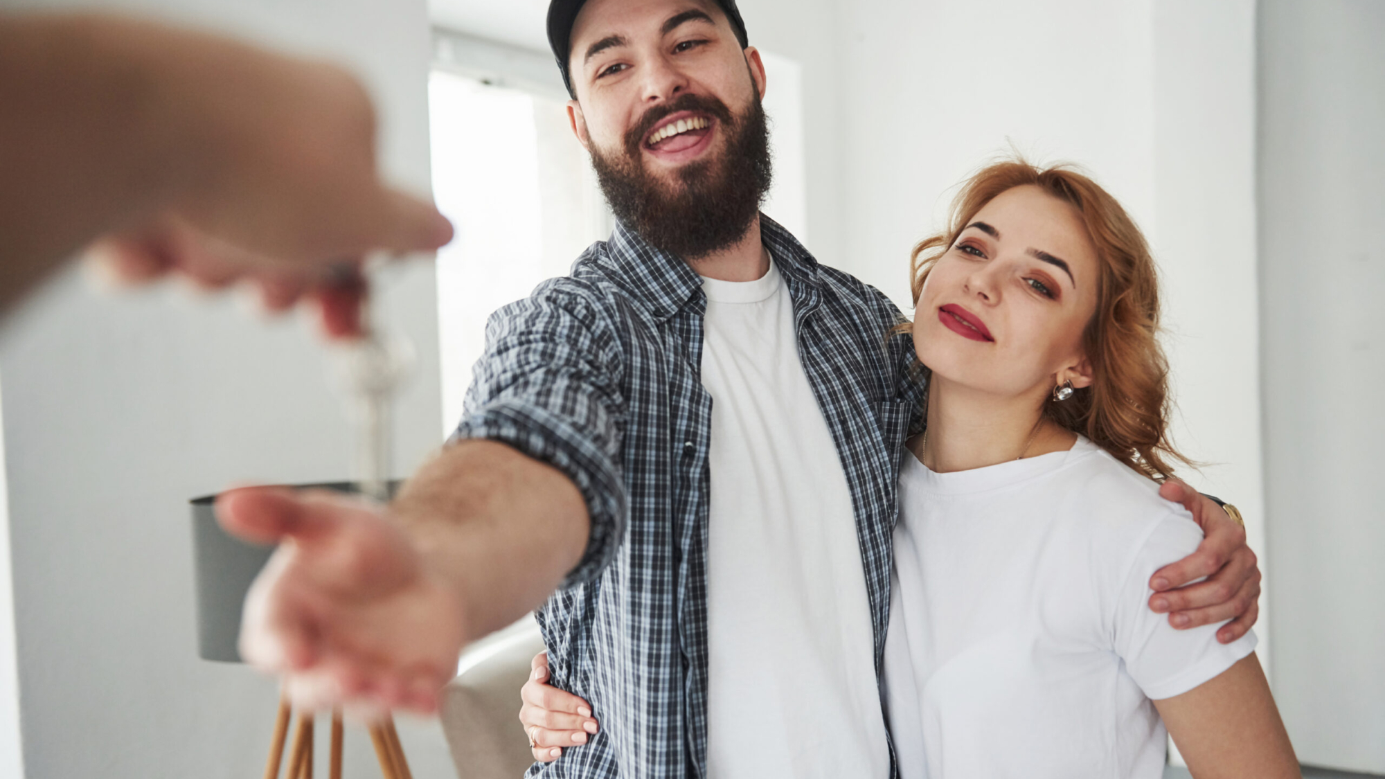 Receiving keys. Happy couple together in their new house. Conception of moving.